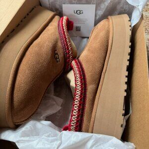 Woman's UGG Tazz Slippers. Tan with red stitching. Brand New, never worn.